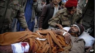 Pakistani soldiers help an injured man as he arrives at hospital in Peshawar