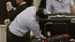 Israeli airport staff check a passenger's luggage at Ben Gurion Airport near Tel Aviv (file image from 13 December)