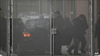 Danish police officers escort one of four suspects, (second from right), arrested on suspicion of planning a shooting attack on the office of a newspaper that published cartoons of the Prophet Muhammad, at a court in Glostrup, west of Copenhagen, 30 December 2010