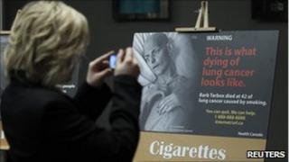 A woman taking a photograph of the new packaging