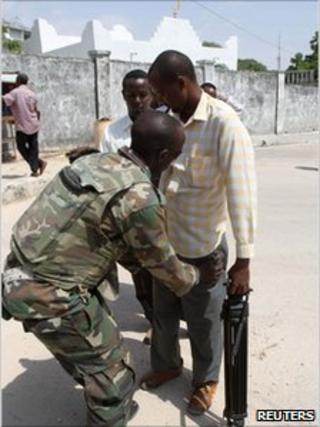 Ugandan peacekeeper searches a journalist in Mogadishu, Somalia, on 30 December 2010
