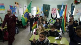 Children wave flags of Latin American countries.