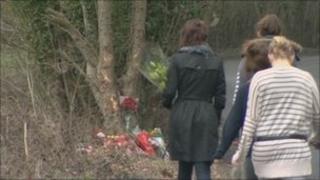 Flowers are left at the scene of the crash