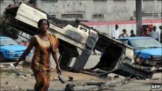 Woman in front of burnt-out UN vehicle ( 30/12/2010)
