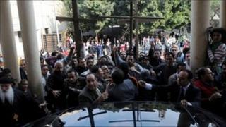 Protesters crowd round a vehicle carrying Egyptian Grand Imam of Al-Azhar Ahmed al-Tayeb at the al-Abasseya Cathedra in Cairo, 2 January 2011.