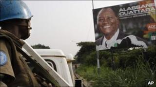 United Nations troops in Abidjan by a billboard of Ivory Coast’s internationally recognised elected leader Alassane Ouattara