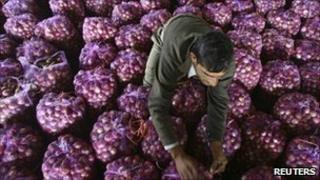 A worker packs onions in India