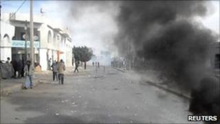 Smoke is seen in a street in Regueb, where funeral processions were held for people shot in recent clashes with police, on 10 January 2011