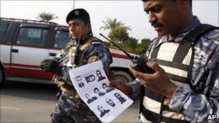 Iraqi policemen holds document showing the escaped detainees