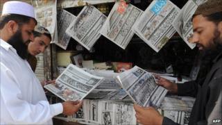 Pakistani men read the headlines at a news stand in Quetta on 4 September 2010