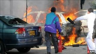 Karachi Electric Supply Company staff extinguish a burning car torched by sacked employees on 20 January 2011