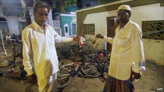 Muslim residents show blood-stained prayer caps at the site of the bombings at the Nurani Mosque at Malegaon on 9 September 2006