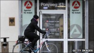 Woman cycles past German job centre