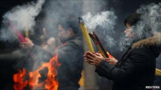 People burn incense at the Old City God Temple in Yuyuan Garden, downtown Shanghai, China