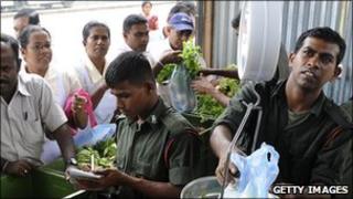 Soldiers sell vegetables from a stall in Colombo