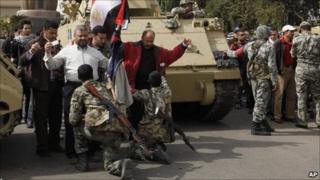 Soldiers search anti-government protesters entering Tahrir Square in Cairo - 4 February 2011