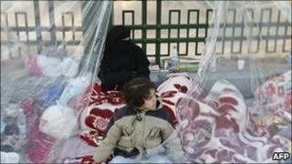 An anti-government protestor wakes up under plastic sheeting in Tahrir Square, Cairo