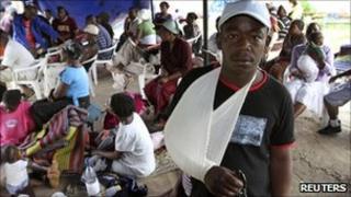 Supporters of the opposition Movement for Democratic Change (MDC) take shelter in a house in Harare, February 7, 2011, after fleeing clashes in the nearby Mbare township