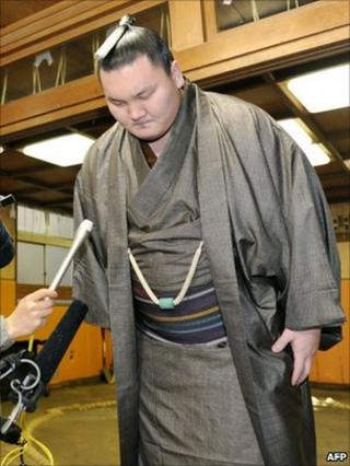 Mongolian-born sumo grand champion, Hakuho bows at the beginning of a press conference at his stable in Tokyo