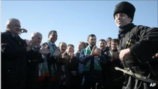Ruud Gullit (third from left) watches a traditional Chechen dancer perform at Grozny airport, 9 February
