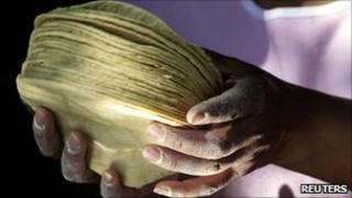 Woman holding a pile of corn tortillas
