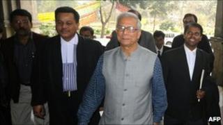 Nobel prize winner and microfinance pioneer Muhammad Yunus (in grey vest) appears for a court hearing in Dhaka