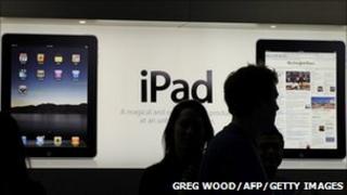 People in front of an iPad advert