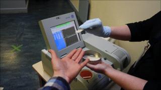 A visitor being checked using a drugs itemiser machine