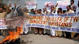 Pakistani protesters burn a US flag