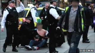 Police holding a man in Trafalgar Square following the brawl