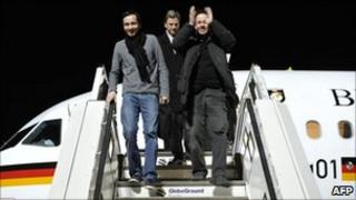 German Foreign Minister Guido Westerwelle (C), Jens Koch (L) and Marcus Hellwig walk off an official German government plane on 20 February 2011