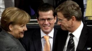 German Chancellor Angela Merkel, Defence Minister Karl-Theodor zu Guttenberg and Foreign Minister Guido Westerwelle, talk prior to a debate at the Bundestag in Berlin, Germany, 21 January 2011