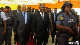South African President Jacob Zuma (L) walks with Ivory Coast's Alassane Ouattara as they arrive for a meeting in Abidjan, 22 February 2011