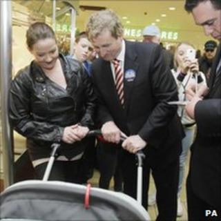 Fine Gael leader Enda Kenny smiles at a baby on the election trail in Dublin, 23 February