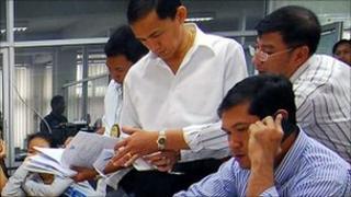 Thai police talk to the Vietnamese women at the Immigration Police Bureau in Bangkok on 24 February 2011