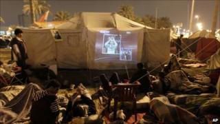 Bahraini demonstrators watch TV in Pearl Square, 17 Feb