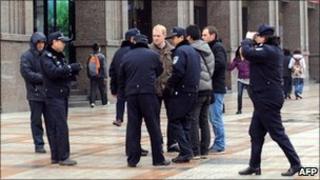 Chinese police surround a group of foreign journalists in the Wangfujing shopping street in Beijing, 27 February 2011