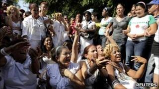 Members of the Ladies in White dissident group shout slogans while surrounded by Cuban government supporters in Havana