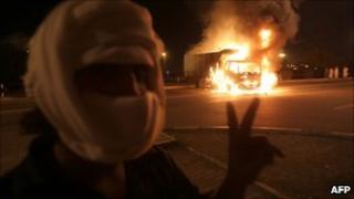 A masked Omani protester flashes victory signs in Muscta, 27 Feb