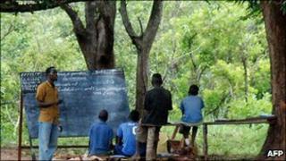 Refugee children from the Democratic Republic of Congo attend class at a makeshift school in the Makpandu camp in the Southern Sudanese region of Western Equatoria (2009)