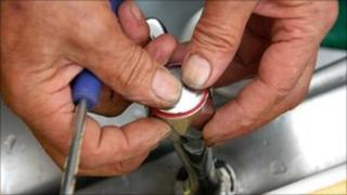 Plumber fixes a tap