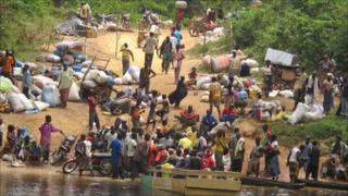 Ivorian fleeing into Liberia across a river