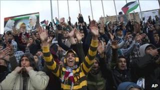 Palestinian football supporters celebrate before the start of a match between Palestine and Thailand in the West Bank town of Al-Ram, 9 March 2011