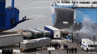 Strikers spray riot police with hoses in the port of Marseille, 10 March