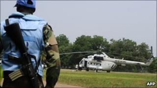 An UN peacekeeper in Ivory Coast stands guard by an UN helicopter - January 2011