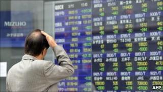 A investor gazes at a share prices board in Tokyo