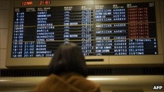 Woman looks at board at Narita airport