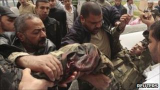 Palestinians push a wounded man on a stretcher after Israeli strikes on the Gaza Strip March 19, 2011.