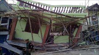 Image released by Democratic Voice of Burma, a soldier stands in front of a house destroyed by an earthquake in Tarlay, Shan state