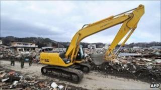 A worker operates the excavator during a clean-up operation in Tarou, north of Morika in Iwate prefecture